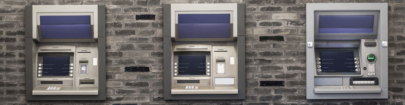 Three ATMs in a brick wall